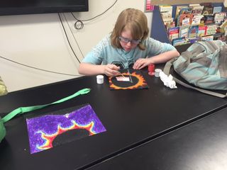 A student works on an eclipse-themed art project.