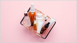 basket with skincare products in on pink background