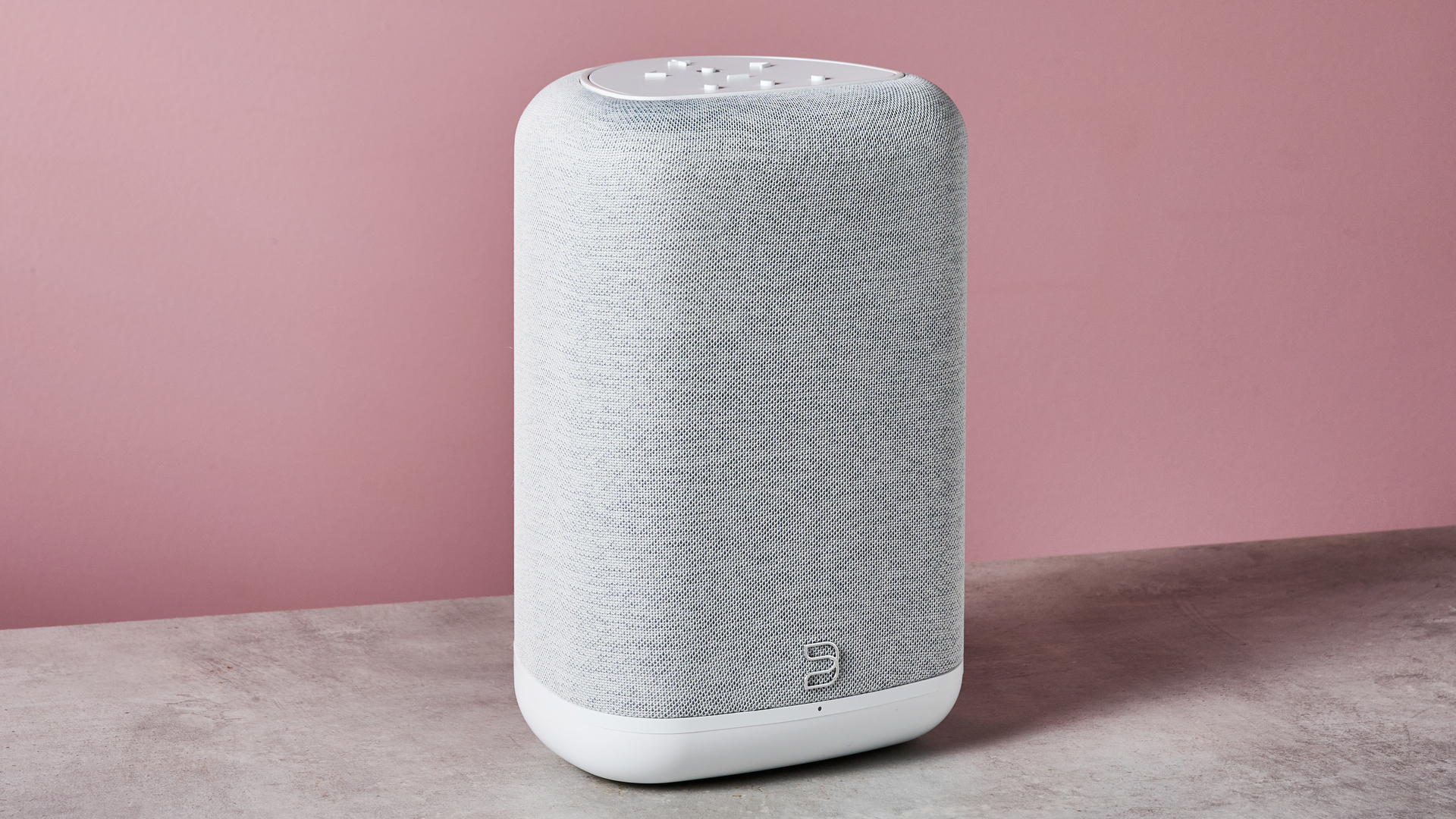 The Bluesound Pulse Flex in front of a pink background.