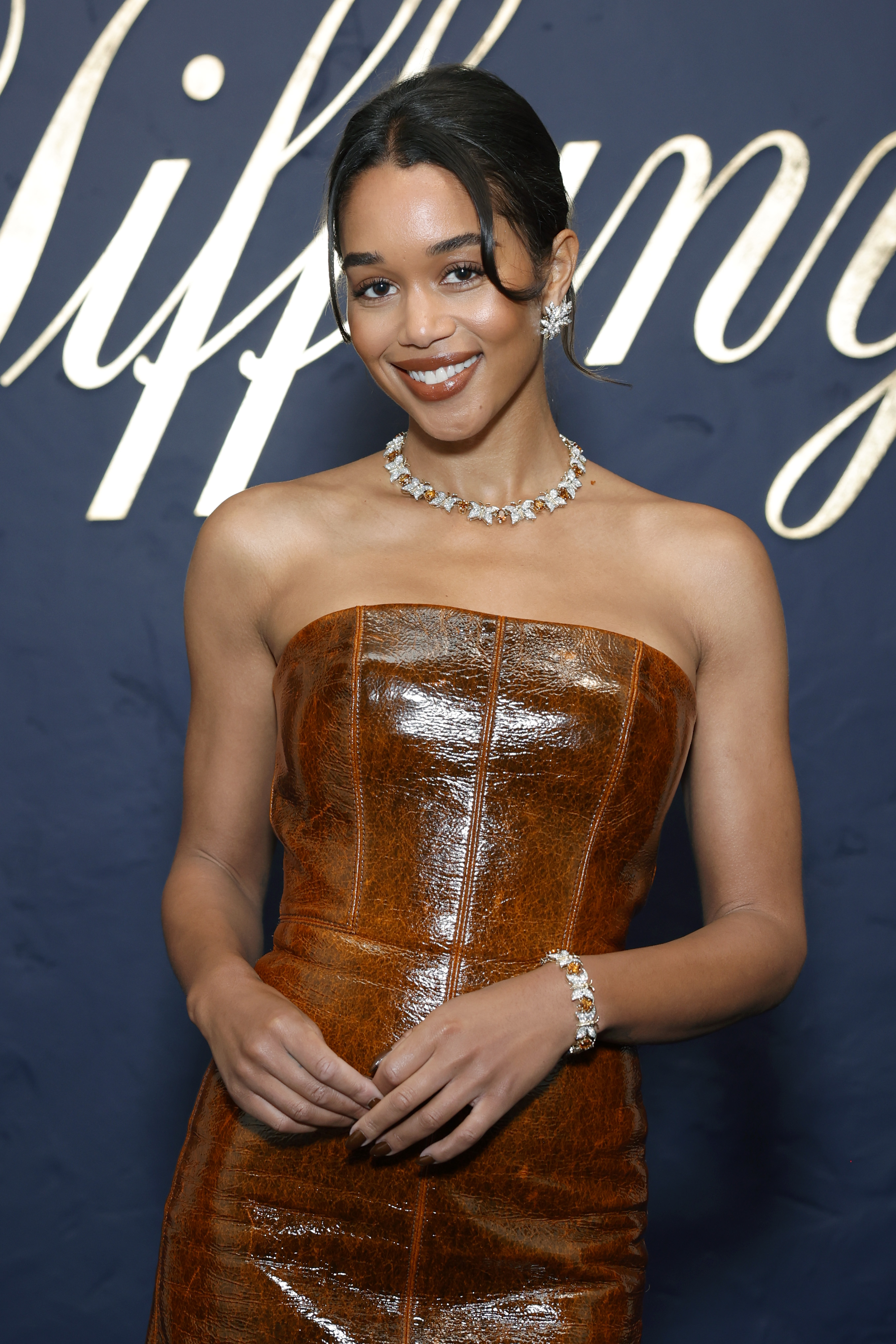 Laura Harrier wearing a brown dress with a diamond necklace