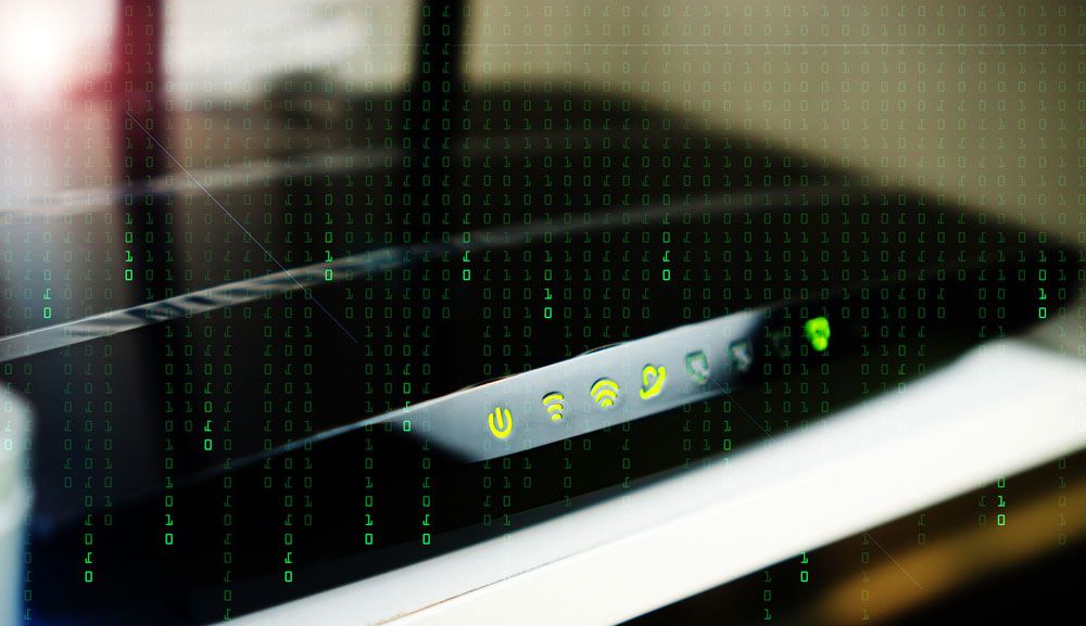 &#039;Matrix&#039;-like green numbers flowing vertically over image of home Wi-Fi router.