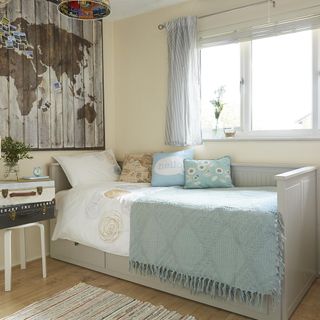 neutral bedroom with wooden wall map and daybed