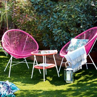 garden with two pink chairs and cushion