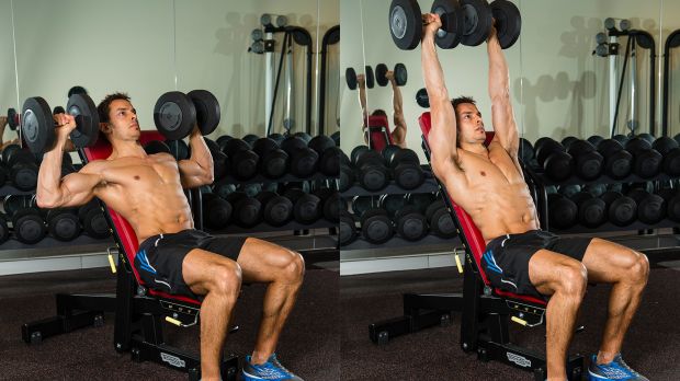 A man performing an incline dumbbell shoulder press as part of a workout plan for muscle gain
