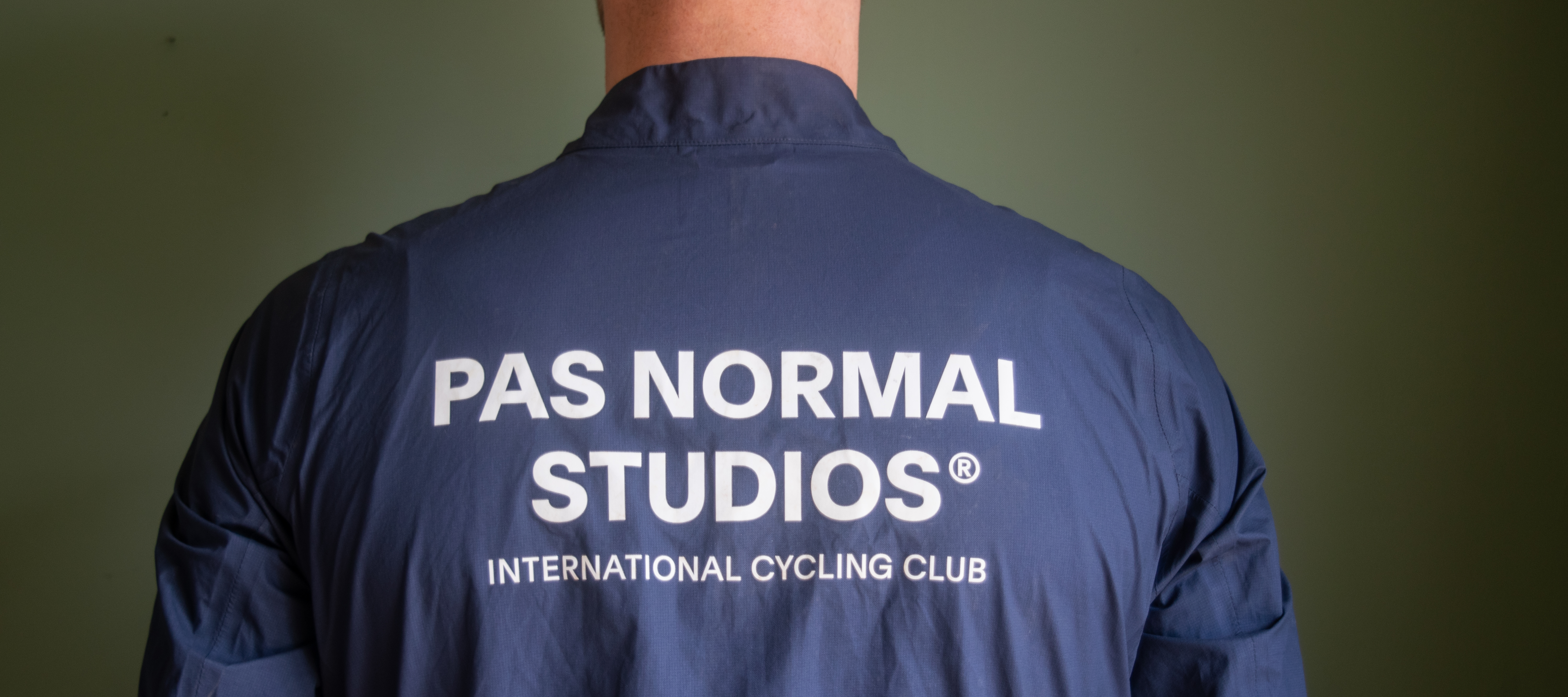 A man wearing a blue Pas Normal waterproof 