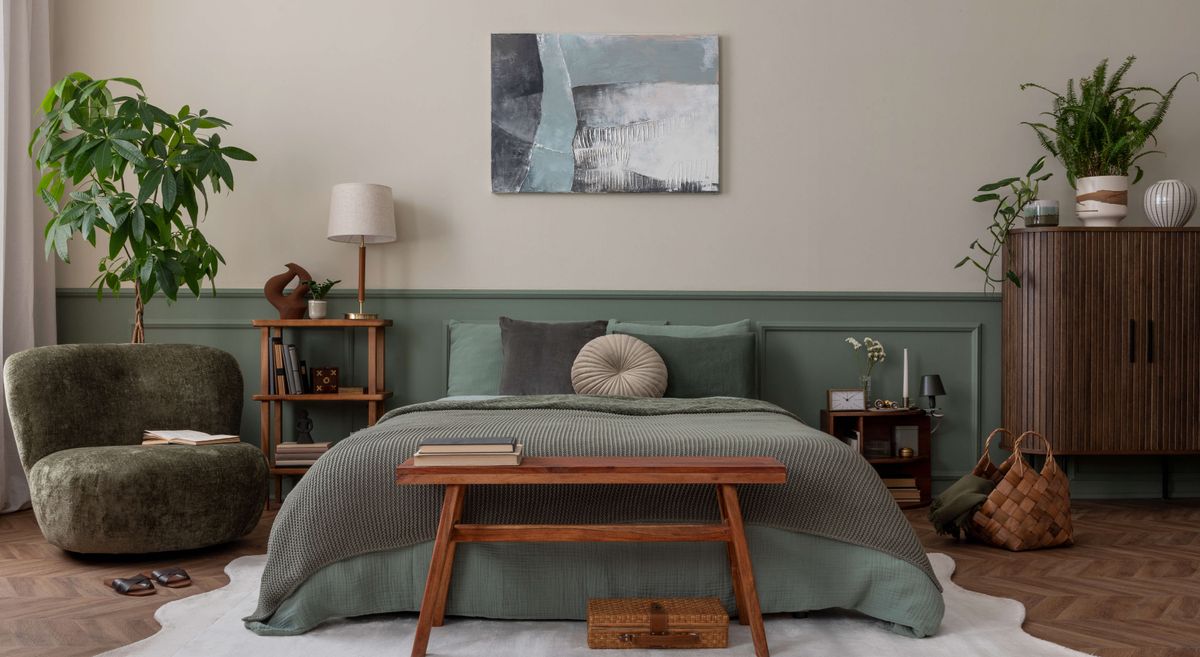 Green bedroom with wallpanelling on the back wall