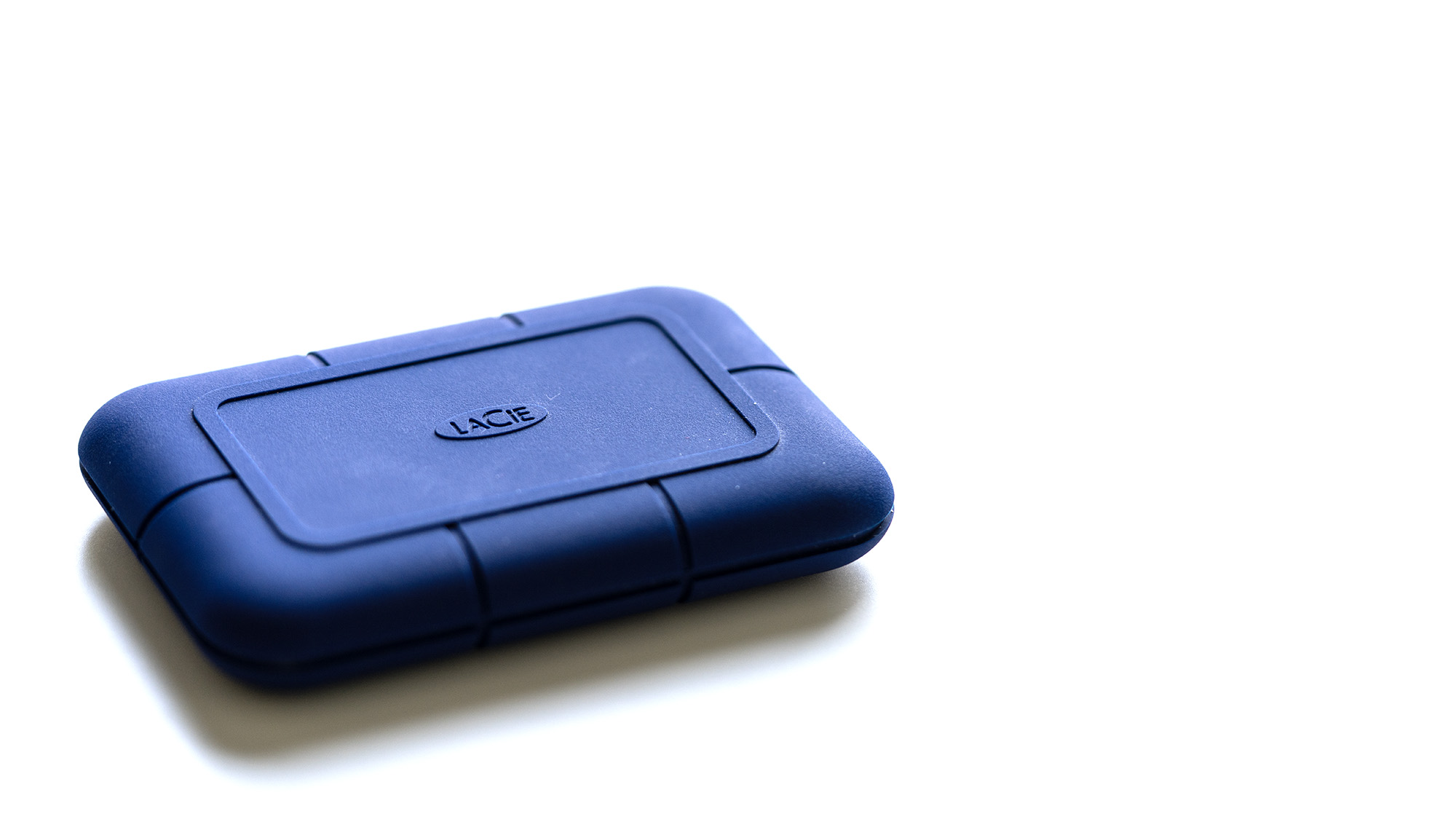 The LaCie Rugged Pro 5 in blue on a laptop and on a white background.