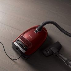 Red Canister vacuum on a wooden floor
