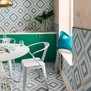 kitchen with white and blue tile design wall green cabinet and white dinning table and chairs