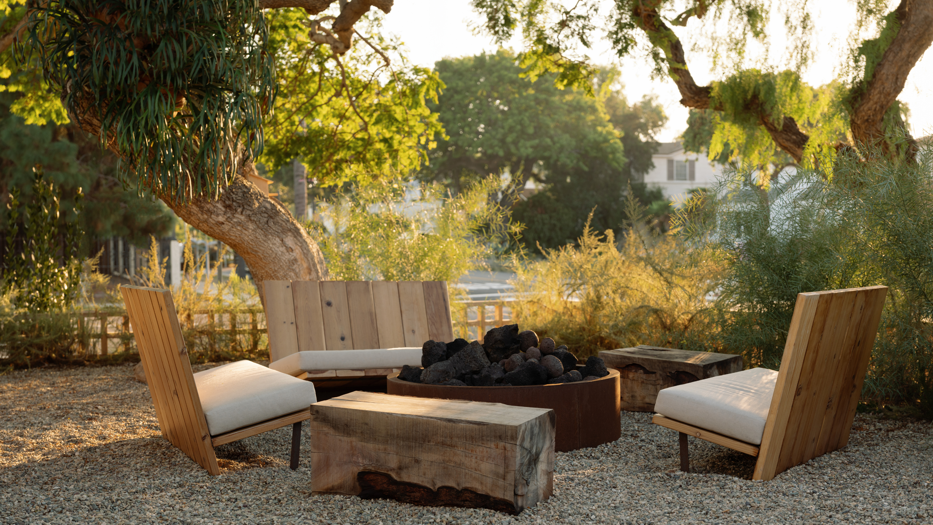 a gravel front yard with a fire pit and soft seating area