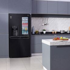 kitchen room with white tiled flooring and black fridge