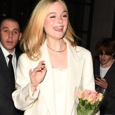 Elle Fanning wearing a cream coat in winter 2025.