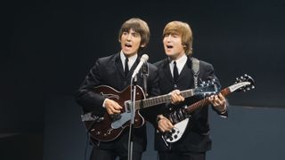 From left, George Harrison (playing a Gretsch 6119 Tennessean guitar with Bigsby vibrato) and John Lennon (playing a Rickenbacker 325 guitar) of English rock and pop group The Beatles perform together on stage for the American Broadcasting Company (ABC) music television show 'Shindig!' at Granville Studios in Fulham, London on 3rd October 1964. The band would go on to play three songs on the show, Kansas City/Hey-Hey-Hey!, I'm a Loser and Boys.
