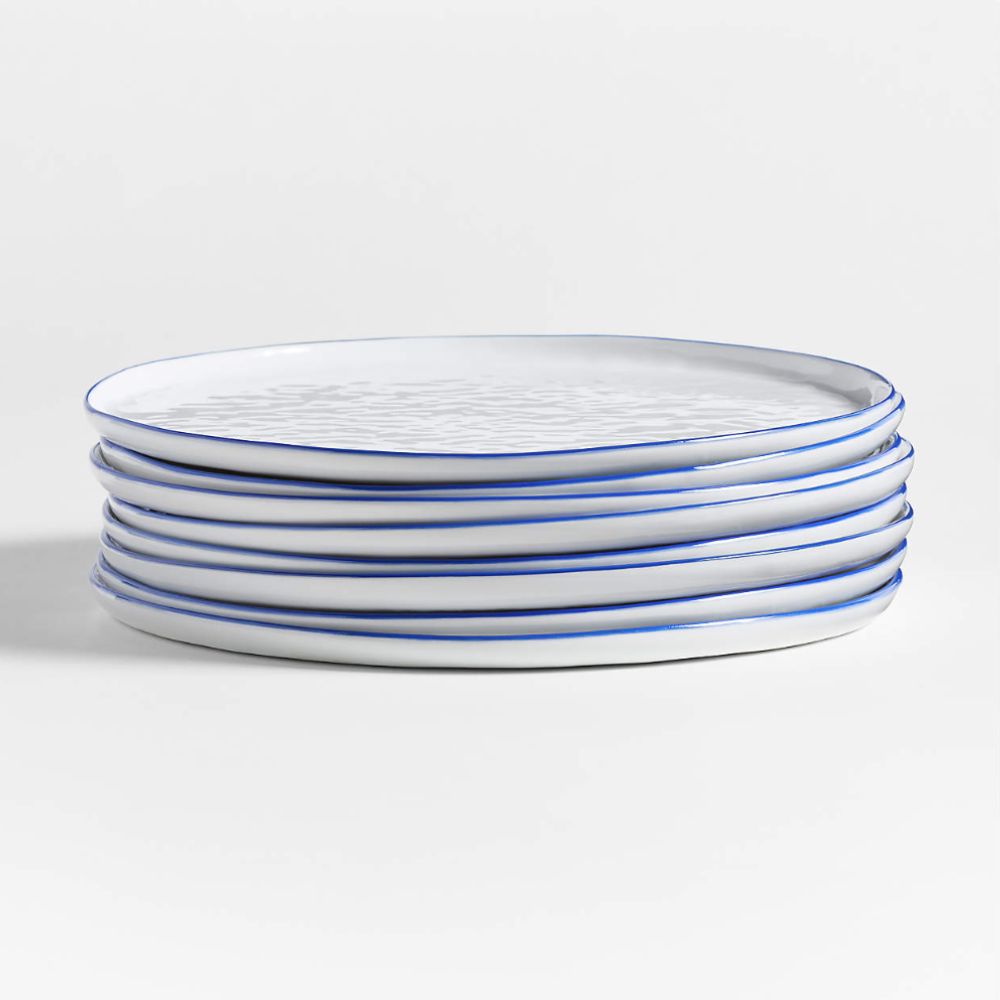 Pile of blue rimmed white plates with a textured surface