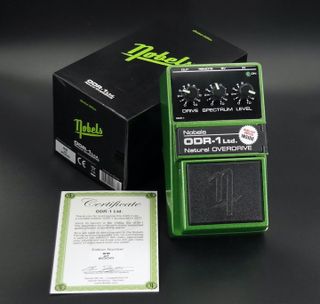 A Nobels ODR-1 Ltd. pedal sits next to its package and certificate of authenticity