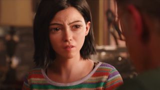 Rosa Salazar looks confused at the table in Alita: Battle Angel.