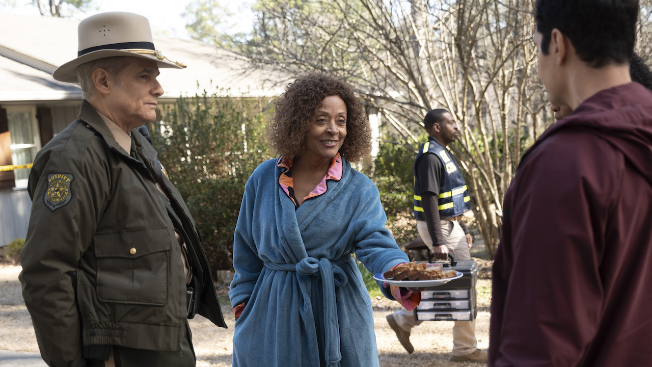 Sheriff Caleb and robed woman offering food in Will Trent Season 3