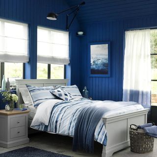 blue bedroom with bed and window blinds