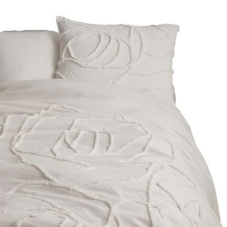 A white comforter set with a rose textured pattern