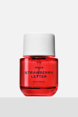 Phlur Strawberry Letter Eau De Parfum in short pink bottle with large white cap on white and grey background 