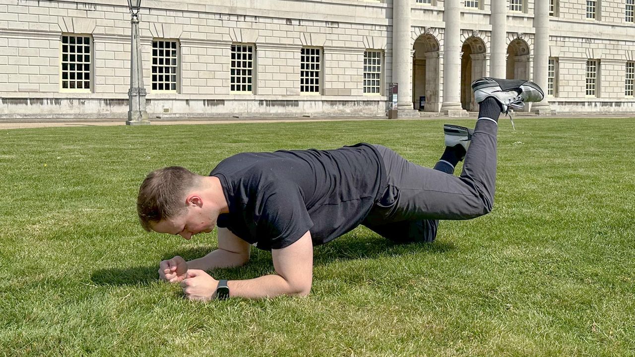 Ollie Thompson performing an alternating kneeling plank