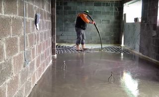 Underfloor heating pipes are being covered in screed