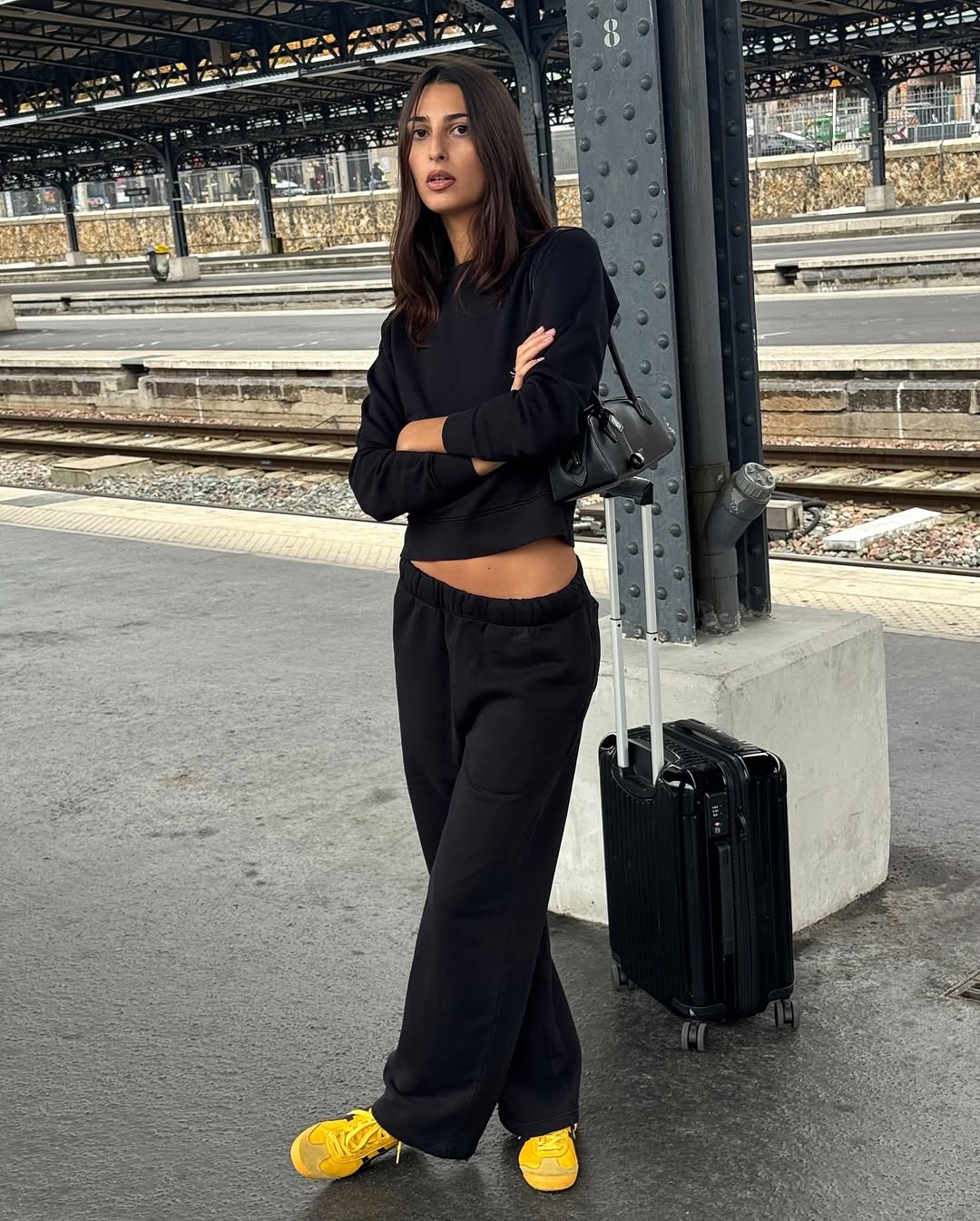 Salome in cropped black knit and yellow trainers