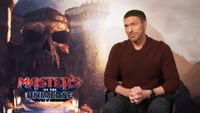 Director Travis Knight sits in front of a "Masters of the Universe" poster. 
