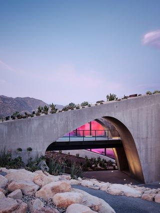 hill house montecito, flowing concrete house in the californian context with arid landscape and a tree around