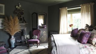 French bedroom with dark painted walls and purple bedding