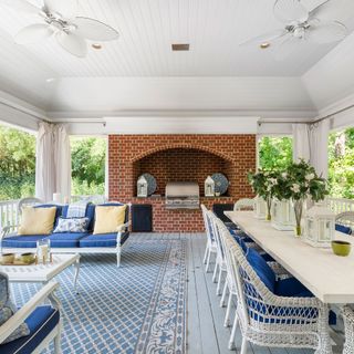 pool house with exposed brick facade, bbq and dining table