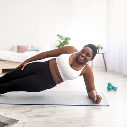 A woman doing one of her go-to 30 minute dumbbell workouts