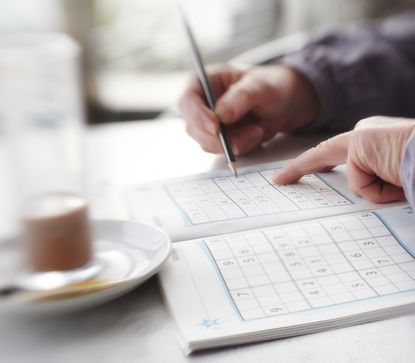 A person works on a Sudoku puzzle.