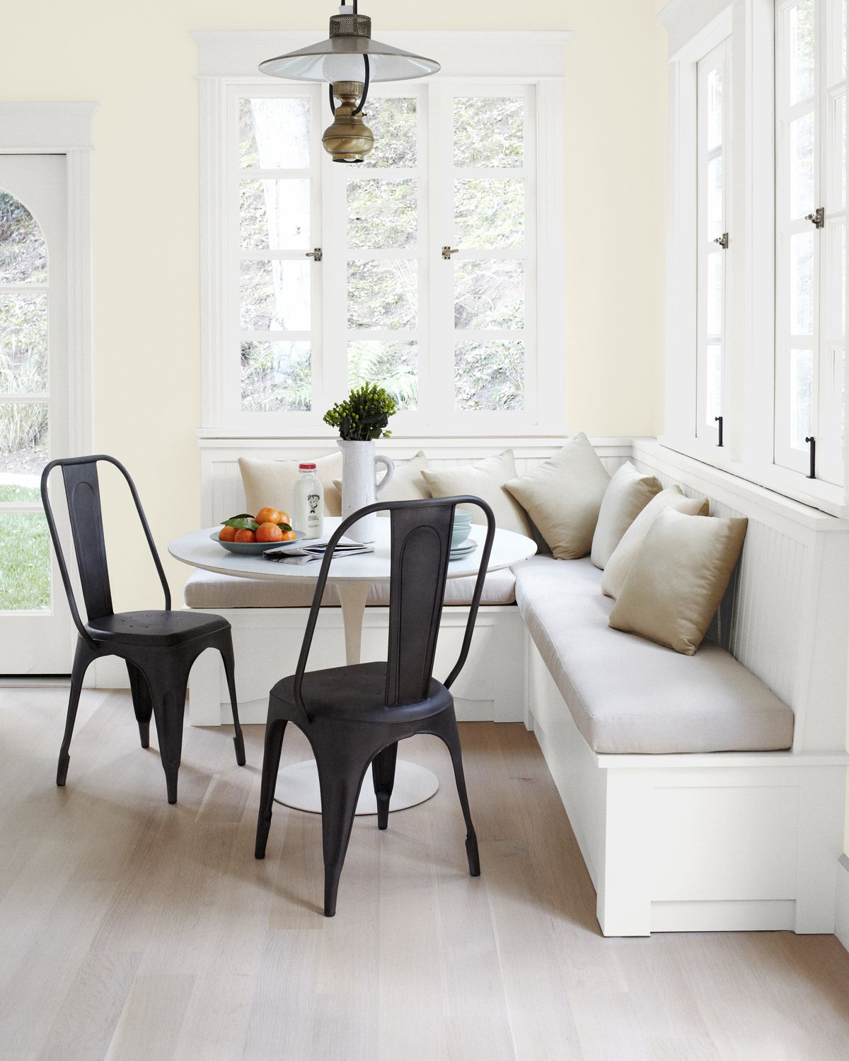 Warm white kitchen dining area with corner booth seating and bistro table