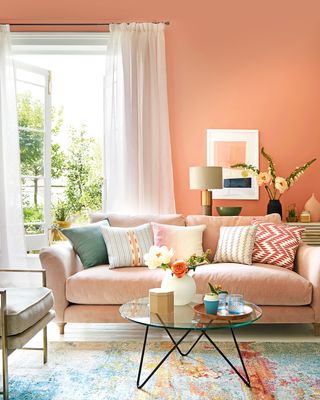 peach coral pink paint color on living room walls with blush pink velvet sofa