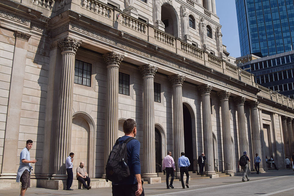 People walk past the Bank of England, which is expected to cut interest rates this week due to rising unemployment and Trump tariffs