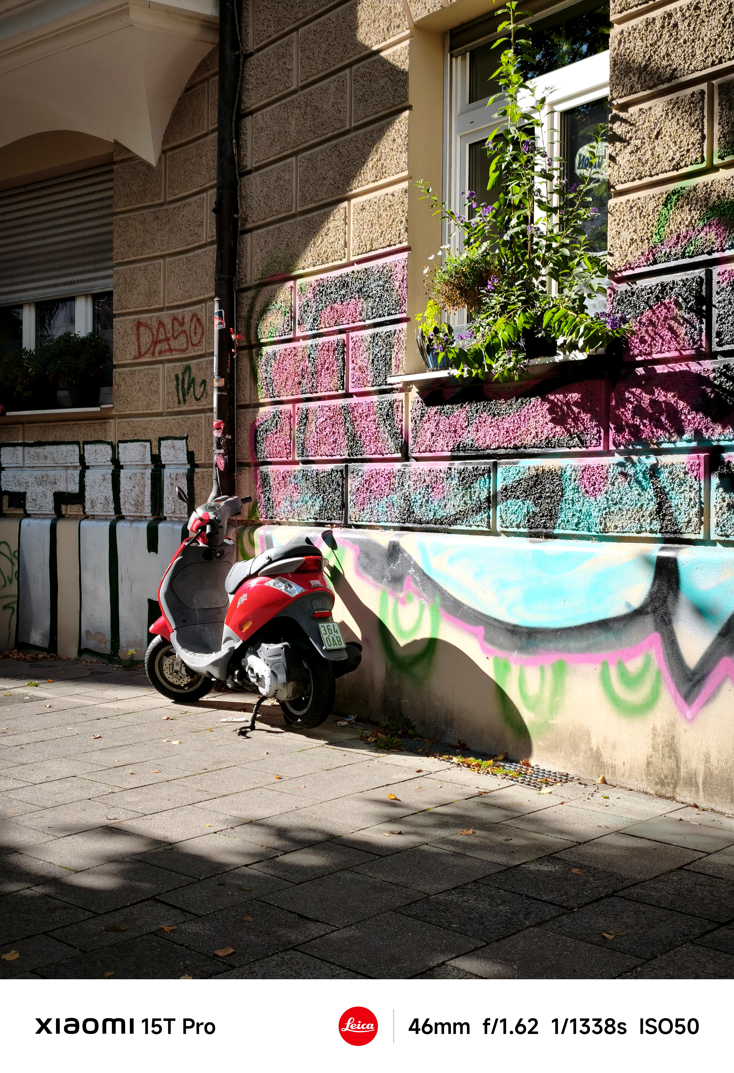 A Vesper motorcycle parked up against the wall covered in graffiti