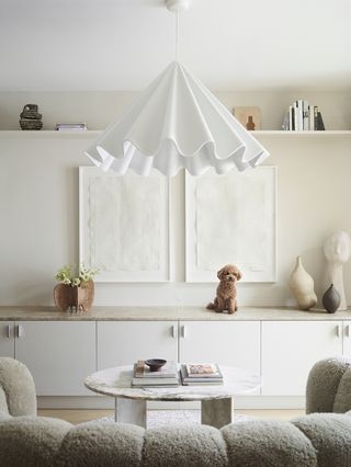 white living room with white sofa and pedant light and small dog