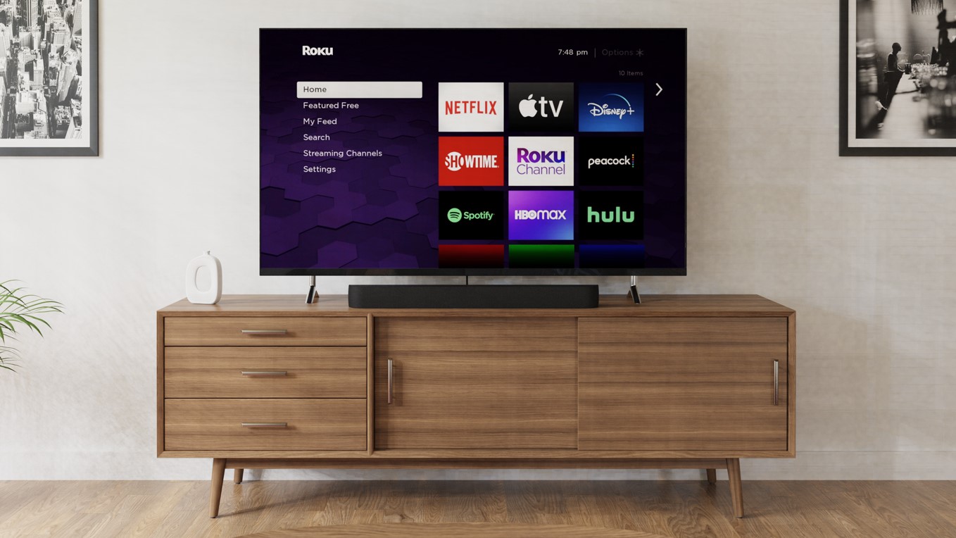 A Roku Streambar Pro below a TV in a living room