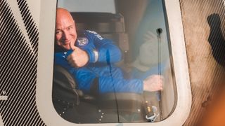 Jeff Bezos giving a thumbs up from inside Blue Origin's New Shepherd capsule