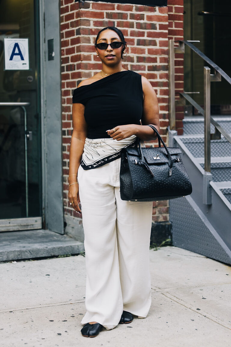 woman wearing white jeans and a black top scarf around her waist