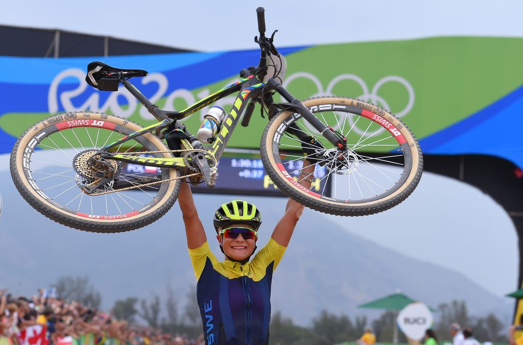 Jenny Rissveds (Sweden) lifts her bike above her head to celebrate gold