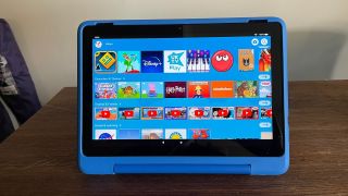 En blå Amazon Fire HD 10 Kids Pro står på ett träfärgat skrivbord.