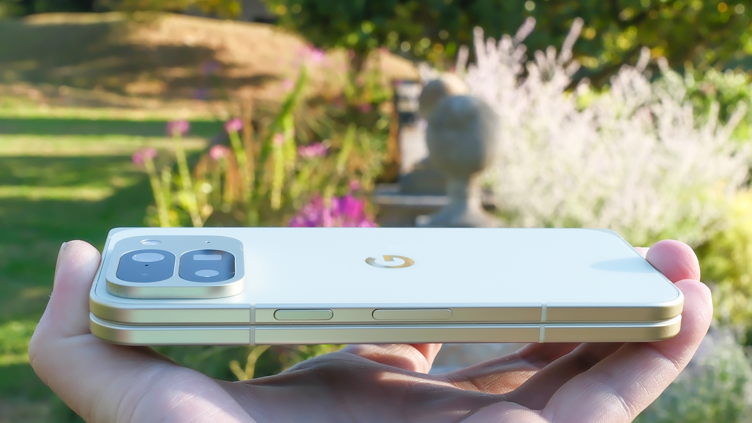 Google Pixel 10 Pro Fold in Jade green outside at a flower garden on a sunny day