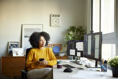 Black woman sitting at her desk with cup of coffee