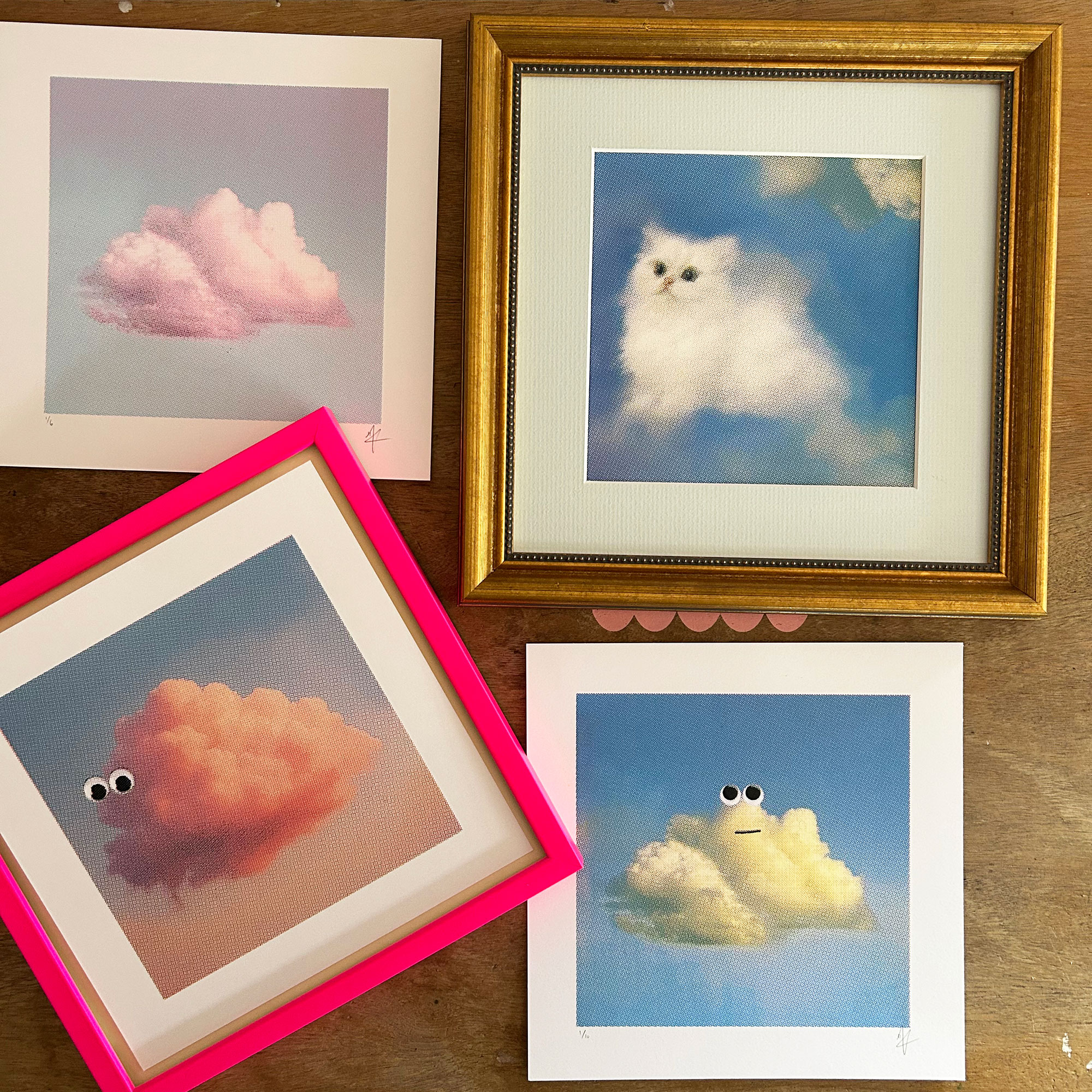 Collection of mounted and framed screen prints of clouds with googly eyes