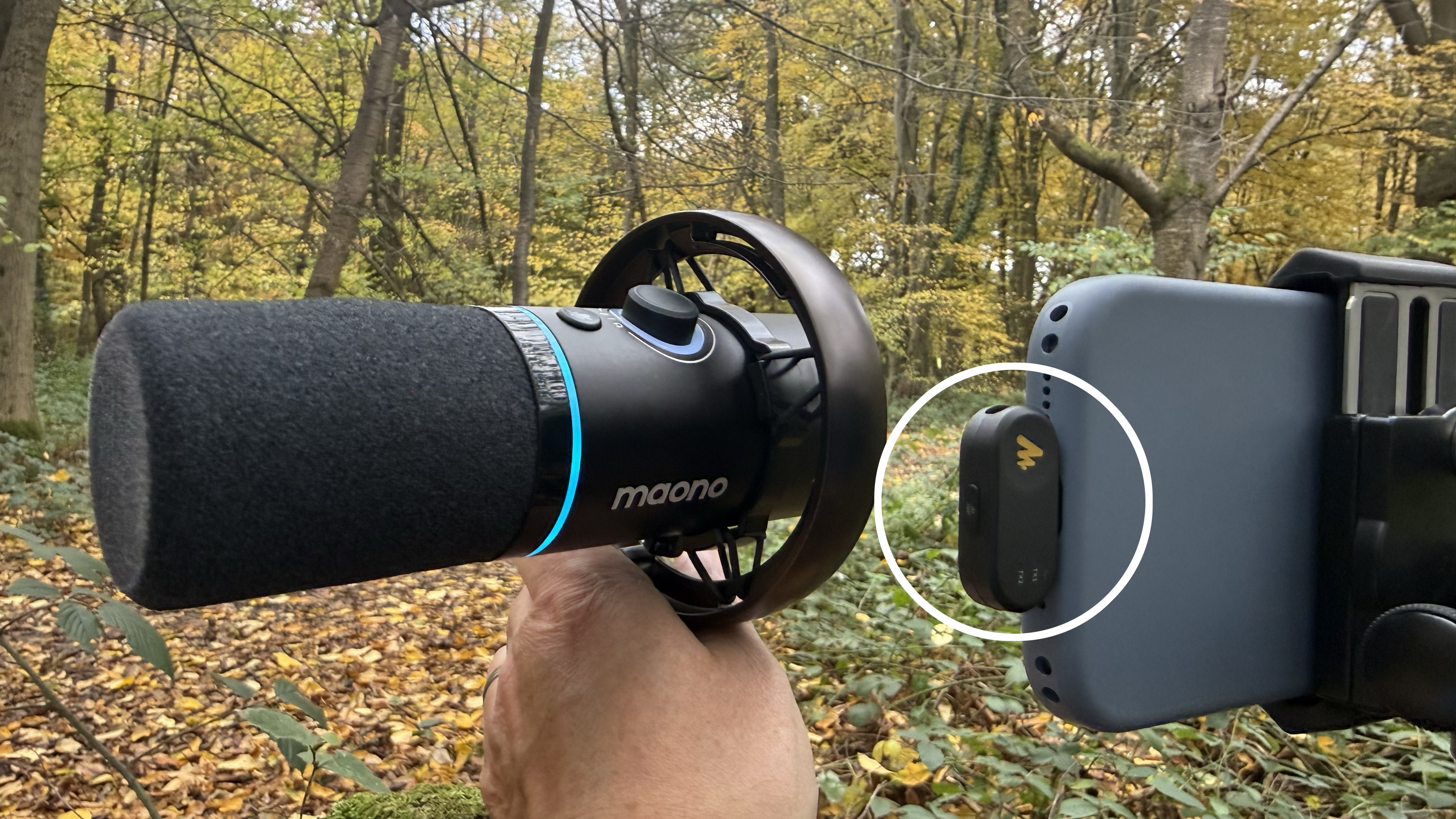 Shot of the PD200W being held next to an iPhone 17. The kit&amp;rsquo;s wireless receiver is plugged into the iPhone&amp;rsquo;s USB-C socket