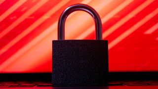 Black padlock sitting on laptop keyboard with red background, representing the BlackLock ransomware group.