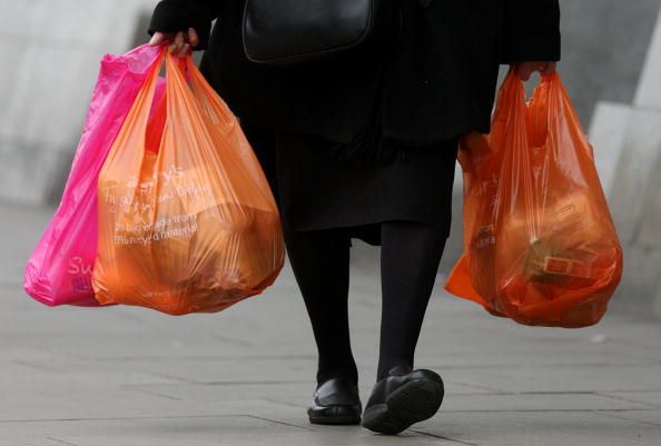 A woman carrying plastic bags.