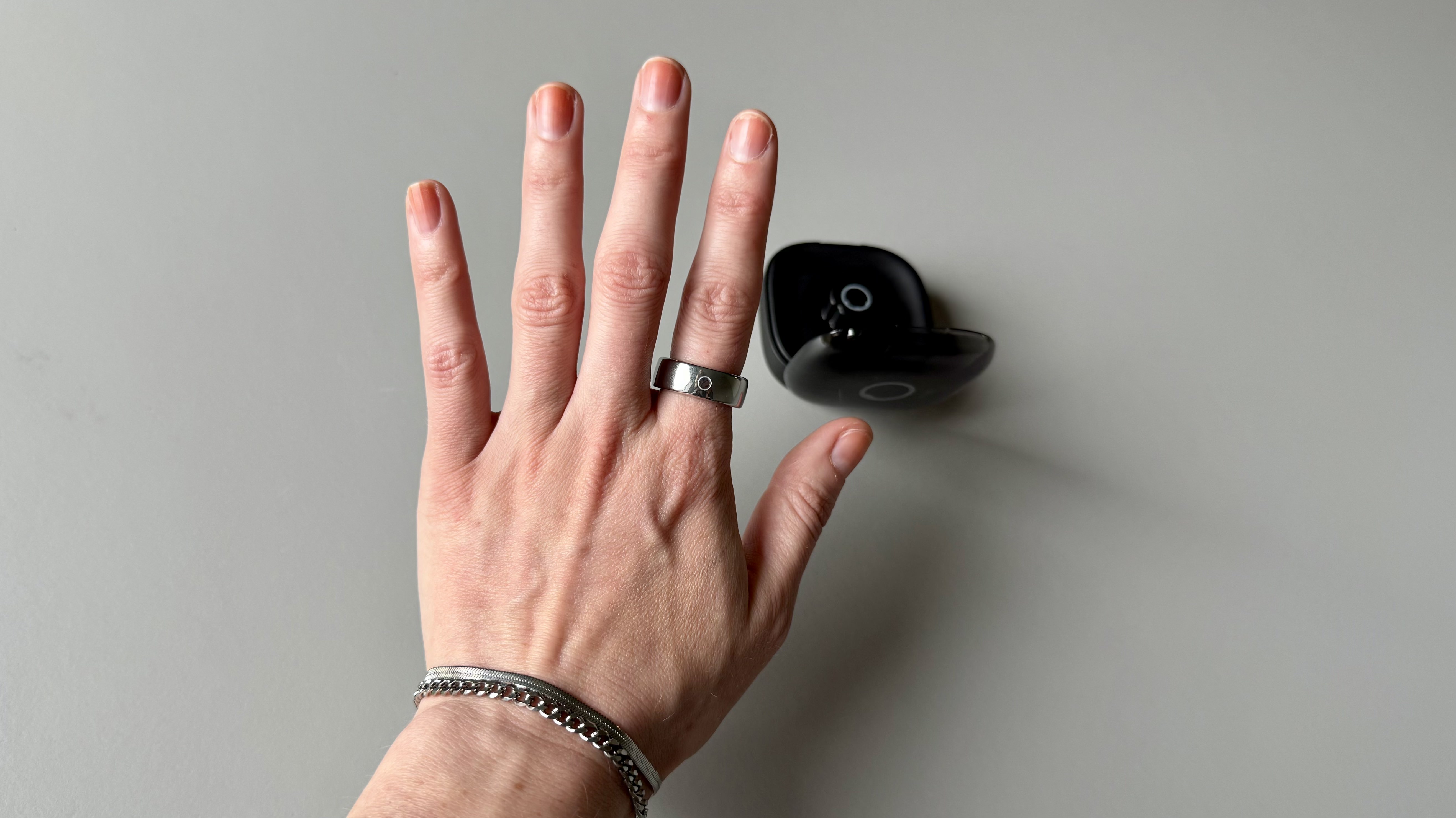 Becca holding the Circular Ring 2 smart ring above a grey surface